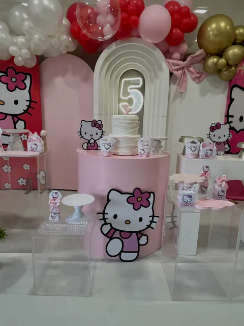 Tema Hello Kitty: decoração em rosa e branco, com bolo de babados e o número 5 em neon